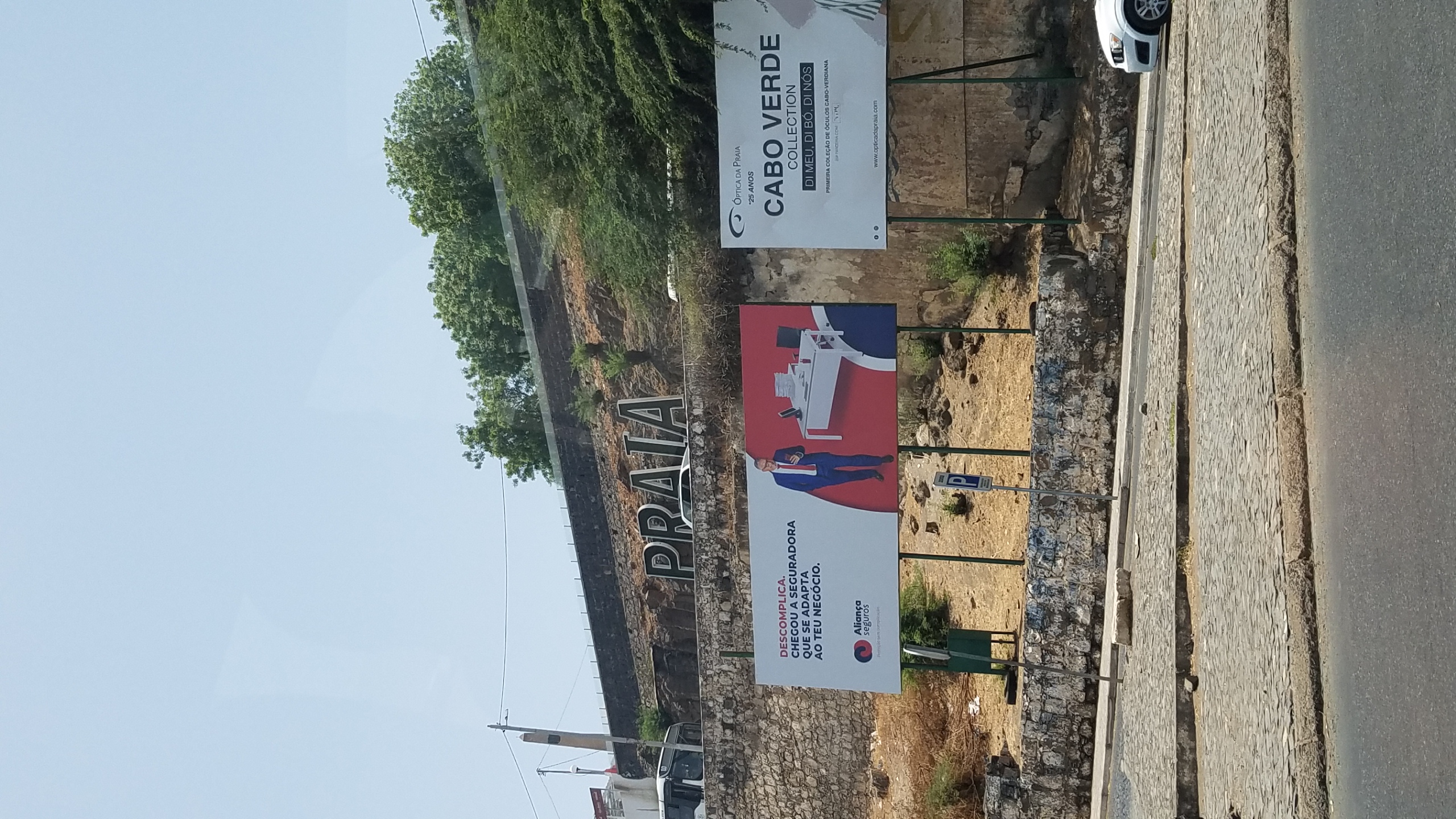 The large PRAIA hillside sign above a stone wall in the capital